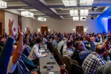 Attendees raising hands in an audience